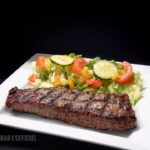 Pièce de viande servi avec salade jardinière